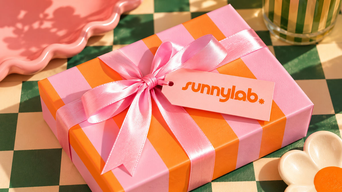 Paquet cadeau rayé rose et orange avec un ruban rose